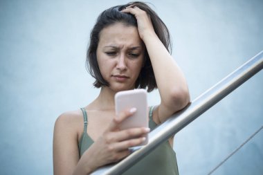 Üzgün kadın şehirde akıllı telefon online içerik kontrol