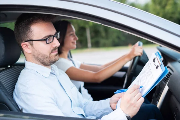 Instructor and young female student, driving lesson — Stock Photo, Image