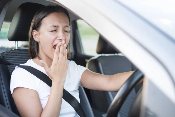 Retrato de mujer cansada conduciendo coche y bostezando —  Fotos de Stock