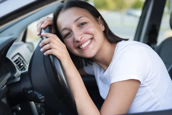 Mujer sonriente sentada en el coche al volante — Foto de Stock