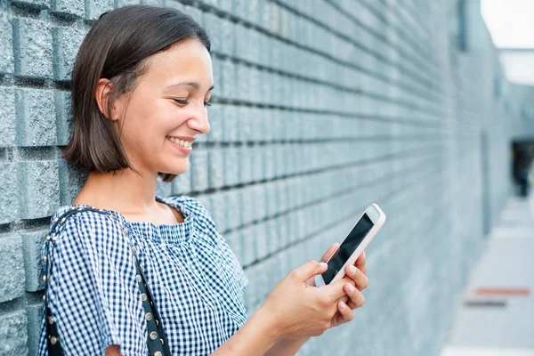 Chica joven mensajes de texto en el móvil al aire libre en la ciudad — Foto de Stock
