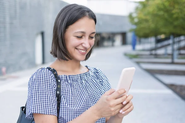 Chica joven mensajes de texto en el móvil al aire libre en la ciudad — Foto de Stock