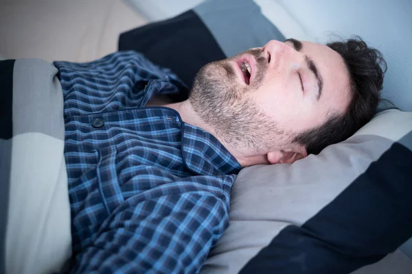 Homem adormecendo em sua cama em casa — Fotografia de Stock