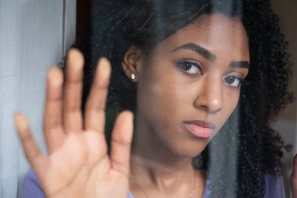 Black girl portrait looking out the window at home — ストック写真
