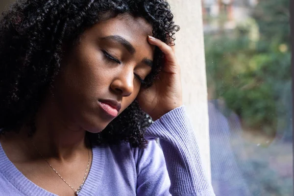 Black girl portrait looking out the window at home — ストック写真