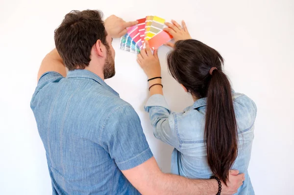 Щаслива пара вибирає кольори для прикраси живопису нового будинку — стокове фото