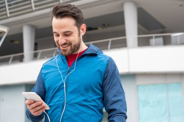Egzersiz sırasında cep telefonu tutan runner sporcu