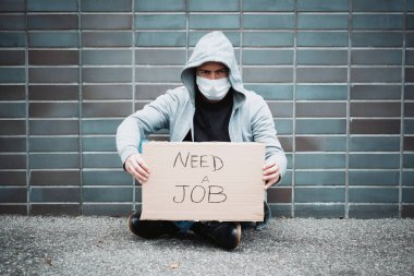 İşsiz bir adam iş arıyor ve ekonomik durgunluk sırasında sokaklarda dileniyor.