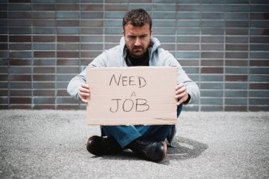 İşsiz bir adam iş arıyor ve sokaklarda dileniyor.