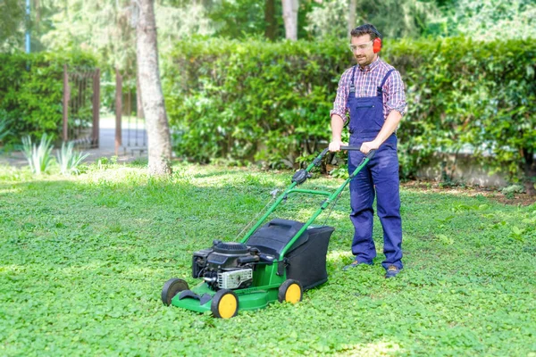 芝刈り機で芝生を刈る男の肖像画 — ストック写真