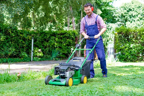 芝刈り機で芝生を刈る男の肖像画 — ストック写真