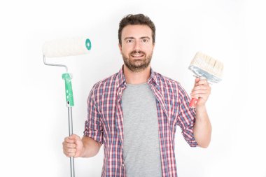 Beyaz arkaplanda boyama araçları tutan adam