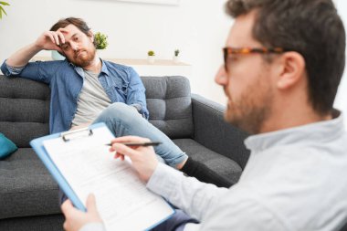 Erkek hastaya danışmanlık yapan doktor, akıl hastalığının teşhisi üzerinde çalışıyor.