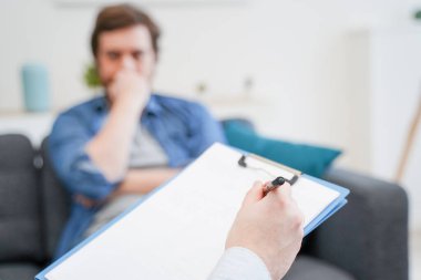 Erkek hastaya danışmanlık yapan doktor, akıl hastalığının teşhisi üzerinde çalışıyor.