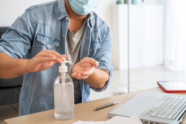 Adam el dezenfektanı ile teknolojiyi temizliyor.