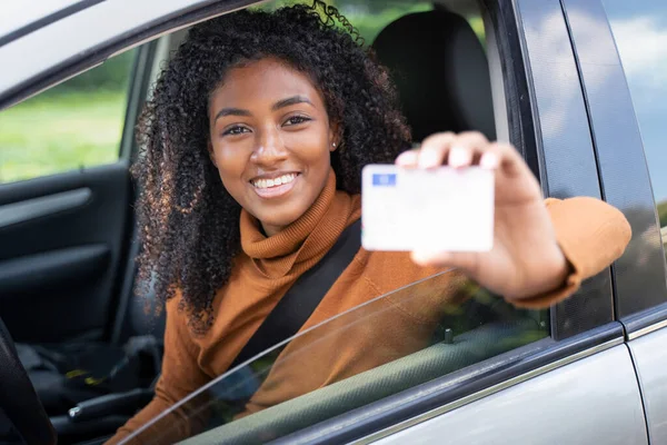 快乐的黑人妇女驾驶着她的新车 她持有汽车牌照 — 图库照片