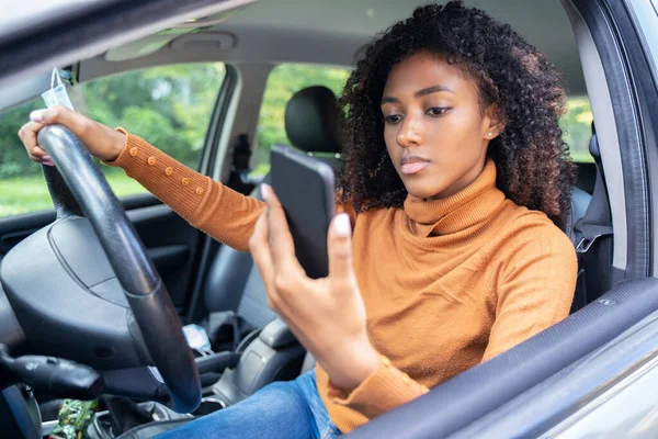 여성이 운전을 스마트폰으로 문자를 보내고 있습니다 — 스톡 사진