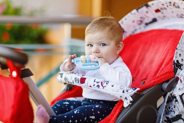 귀여운 작은 아름 다운 아기 소녀 유모차 또는 유모차에 앉아서 엄마를 기다리고. 파란 눈을 가진 행복 한 웃는 아이. — 스톡 사진