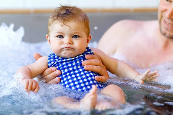 Happy middle-aged father swimming with cute adorable baby girl in swimming pool. — Stock Photo, Image