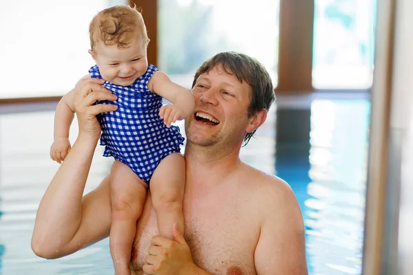 Happy middle-aged father swimming with cute adorable baby girl in swimming pool. — Stock Photo, Image