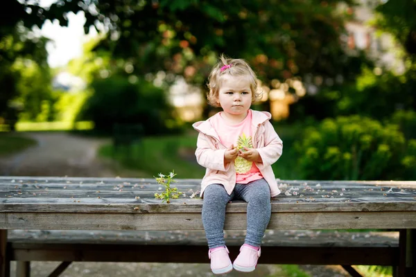 Carino adorabile bambina che gioca con fiori di castagno in fiore. Bambino piccolo che va a fare una passeggiata nella giornata di sole . — Foto Stock