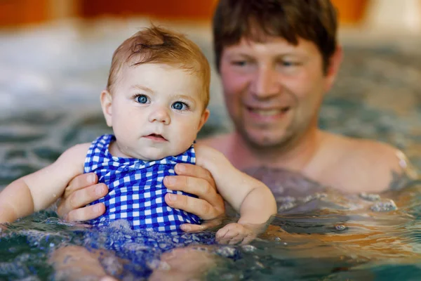 Glücklicher Vater mittleren Alters schwimmt mit süßen entzückenden kleinen Mädchen im Schwimmbad. — Stockfoto