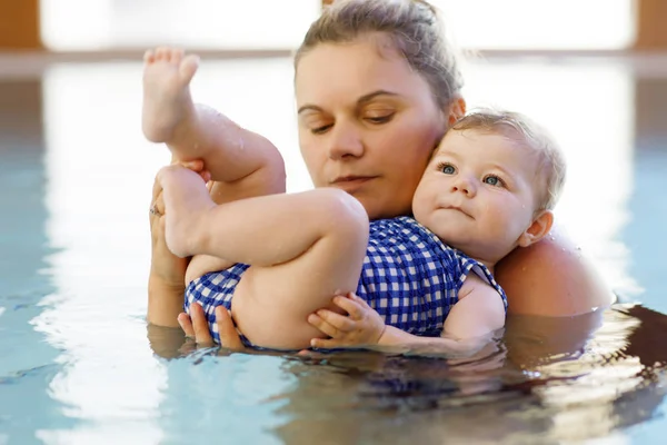 Szczęśliwą matką pływanie z cute adorable baby girl córka w basenie spędzać wakacje spa — Zdjęcie stockowe