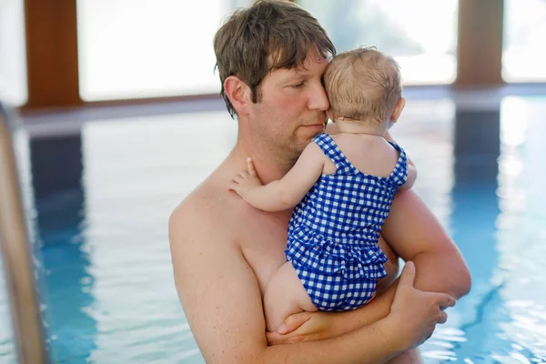 Happy middle-aged father swimming with cute adorable baby girl in swimming pool. — Stock Photo, Image