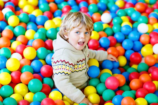 Petit garçon jouant à des boules en plastique colorées aire de jeux — Photo