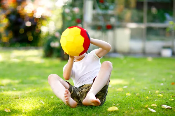 Aktif çocuk mutlu çocuk futbol topu Alman bayrağı renklerde oynamak. Sağlıklı çocuk futbol oyunu ve eylem açık havada ile eğleniyor — Stok fotoğraf