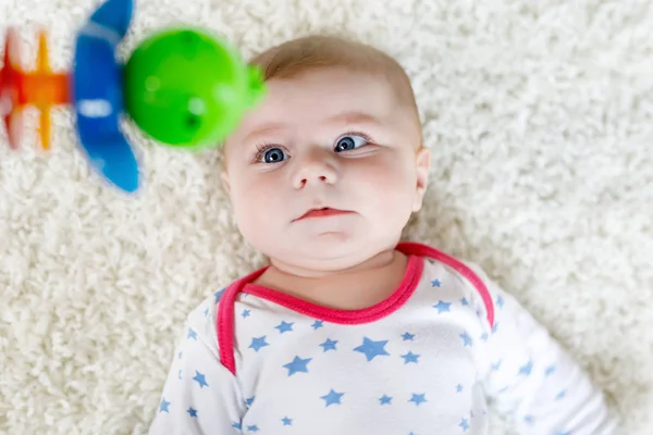 Cute baby girl playing with colorful wooden rattle toy — Stock Photo, Image