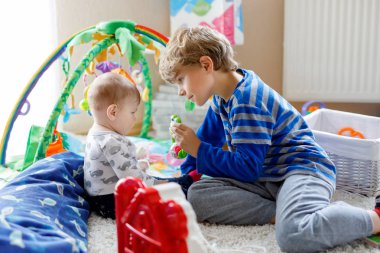 Yeni doğan bebek kız, sevimli kız kardeşi olan mutlu küçük çocuk çocuk. Kardeşler. Kız ve erkek birlikte oynayan bebek. Büyük çocuk gösteren bebek kaynıyor. Aile ve aşk