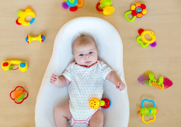 Söt baby flicka som leker med färgglad skallra leksaker — Stockfoto