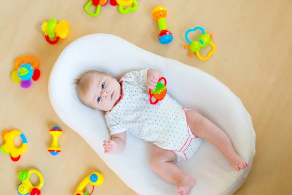 Cute baby girl playing with colorful rattle toys — Stock Photo, Image