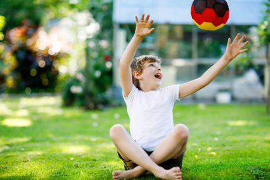 Aktif çocuk mutlu çocuk futbol topu Alman bayrağı renklerde oynamak. Sağlıklı çocuk futbol oyunu ve eylem açık havada ile eğleniyor