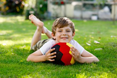 Aktif çocuk mutlu çocuk futbol topu Alman bayrağı renklerde oynamak. Sağlıklı çocuk futbol oyunu ve eylem açık havada ile eğleniyor