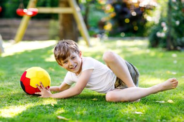 Aktif çocuk mutlu çocuk futbol topu Alman bayrağı renklerde oynamak. Sağlıklı çocuk futbol oyunu ve eylem açık havada ile eğleniyor