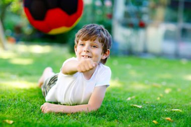 Aktif çocuk mutlu çocuk futbol topu Alman bayrağı renklerde oynamak. Sağlıklı çocuk futbol oyunu ve eylem açık havada ile eğleniyor