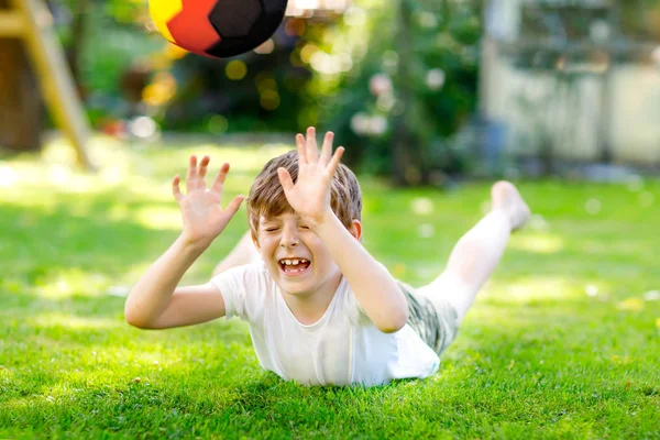 Aktif çocuk mutlu çocuk futbol topu Alman bayrağı renklerde oynamak. Sağlıklı çocuk futbol oyunu ve eylem açık havada ile eğleniyor