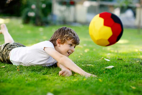 Aktif çocuk mutlu çocuk futbol topu Alman bayrağı renklerde oynamak. Sağlıklı çocuk futbol oyunu ve eylem açık havada ile eğleniyor