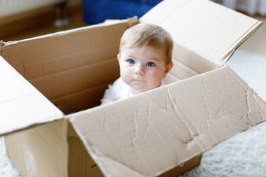 Bir posta kutusunda oturan bebek kız. Mavi gözlü şirin bebek