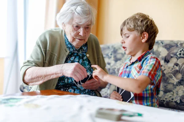Ενεργό μικρό παιδί προσχολικής ηλικίας αγόρι και grand γιαγιά παίζει παιχνίδι καρτών μαζί στο σπίτι — Φωτογραφία Αρχείου