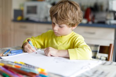 Yorgun çocuk çocuk evde renkli kalemler ile mektup yazma ödev yapma