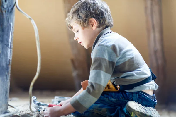 Liten unge pojke hjälper med leksak verktyg på byggarbeten webbplats. — Stockfoto