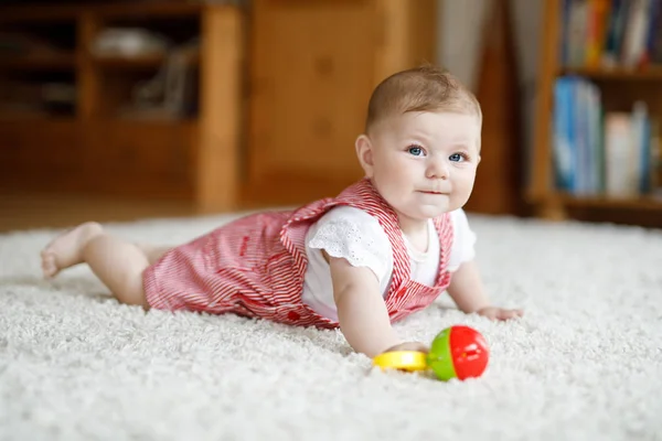 Bébé mignon jouant avec le jouet éducatif de hochet coloré. Lttle fille regardant la caméra et rampant — Photo