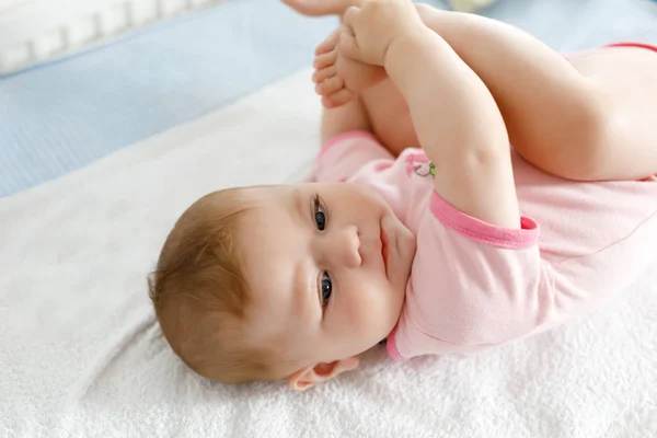 Cute baby taking feet in mouth. Adorable little baby girl sucking foot. — Stock Photo, Image