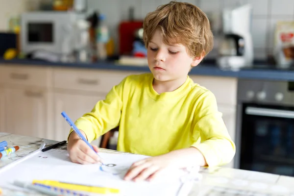 Müder Junge zu Hause macht Hausaufgaben und schreibt Briefe mit bunten Kugelschreibern — Stockfoto