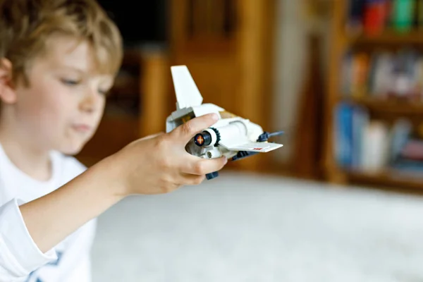 Boldog gyerek kisfiú játszik a játék űrrepülőgép. — Stock Fotó