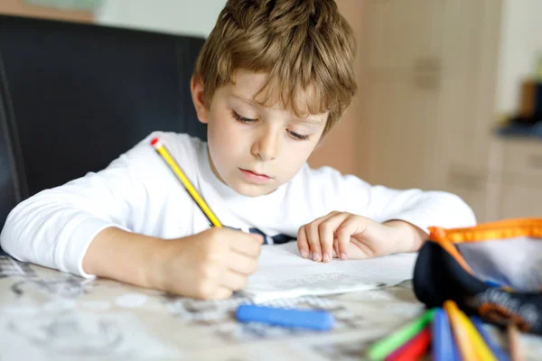 Tired kid boy at home making homework writing letters with colorful pens — Stock Photo, Image