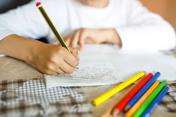 Niño haciendo deberes y escribiendo ensayo de historia. Clase primaria o primaria. Primer plano de manos y lápices de colores —  Fotos de Stock